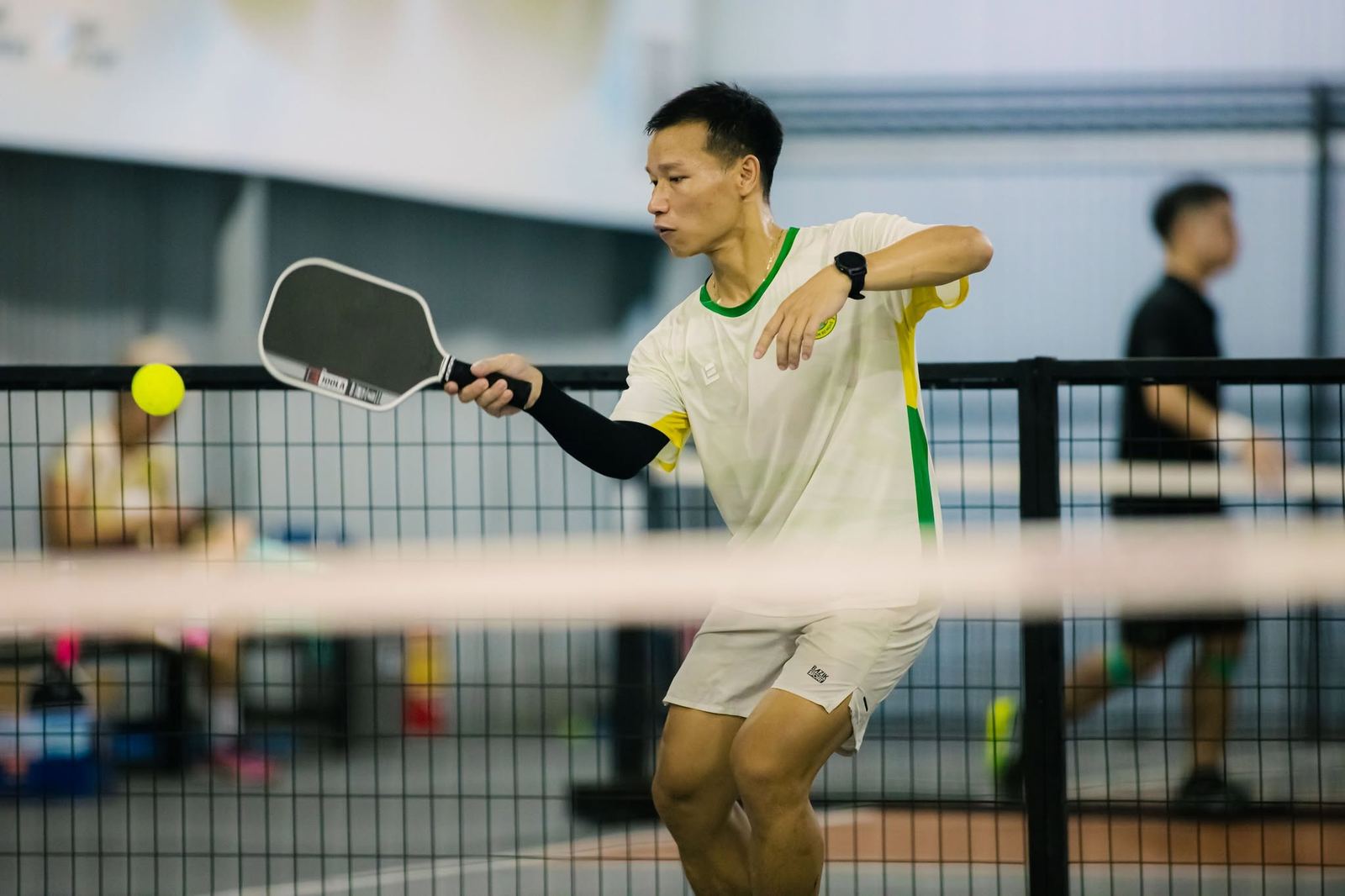 Coach Kim đánh forehand trên sân pickleball trong nhà